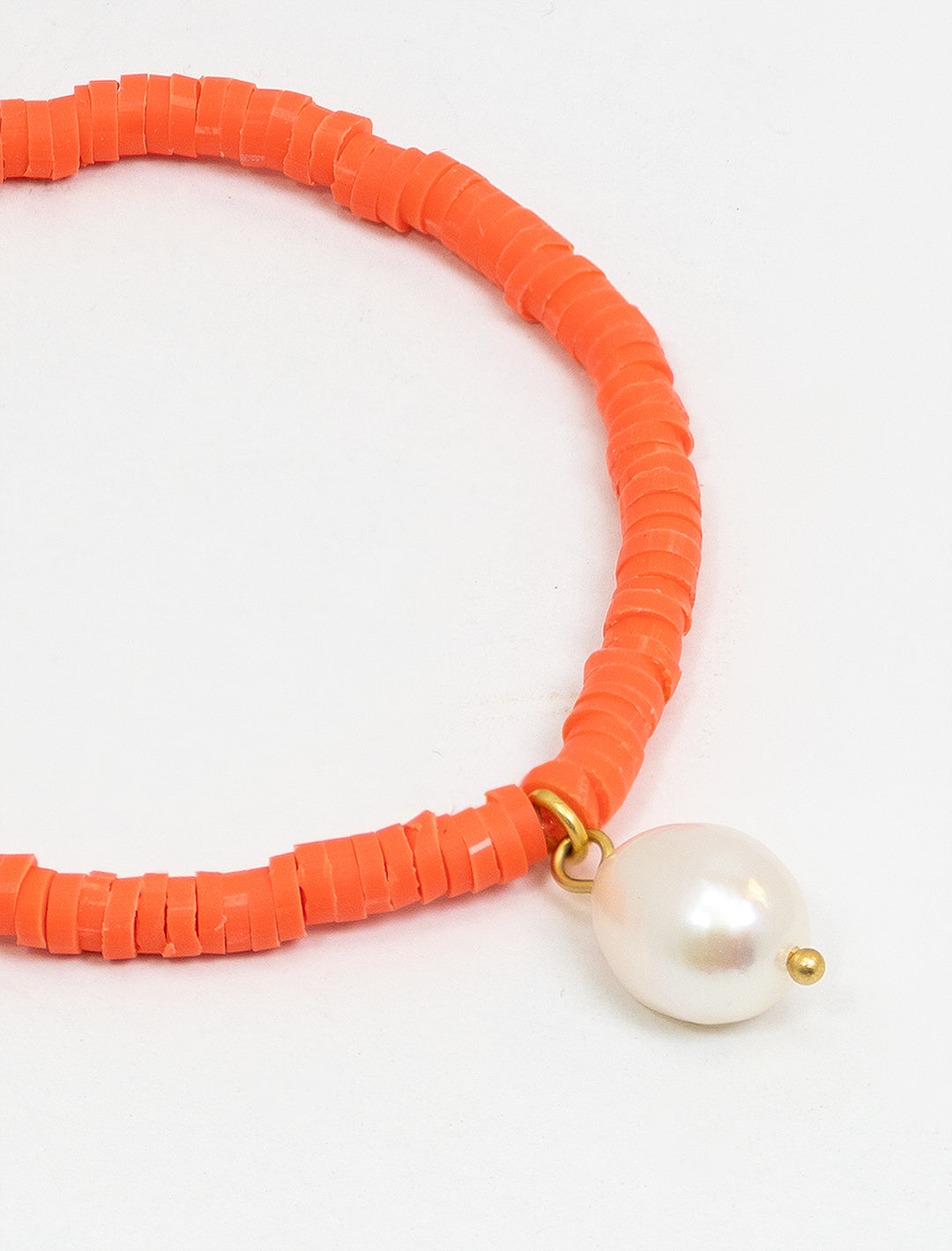 Close-up view of Clare V.'s beaded disc stretch bracelet with coral and pearl.