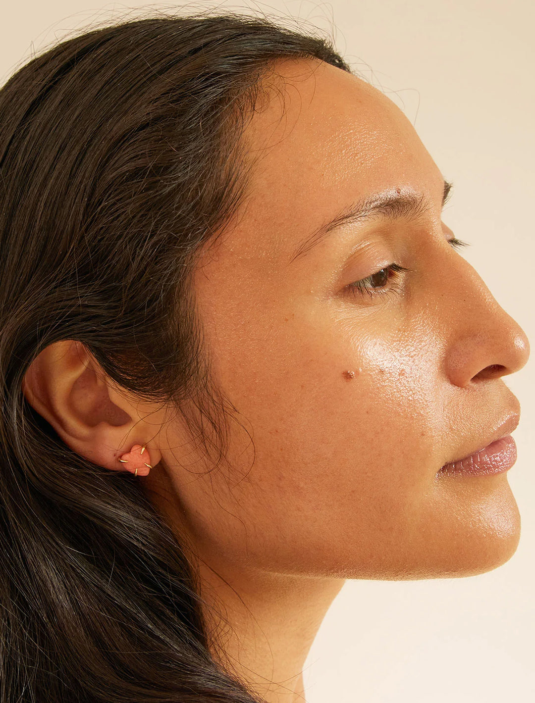 Model wearing Clare V.'s stone heart studs in coral.