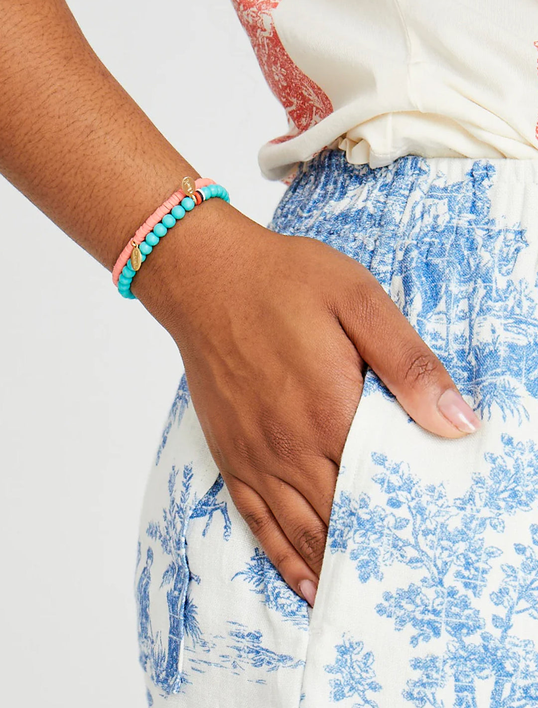 Model wearing Clare V.'s stone beaded stretch bracelet in turquoise.