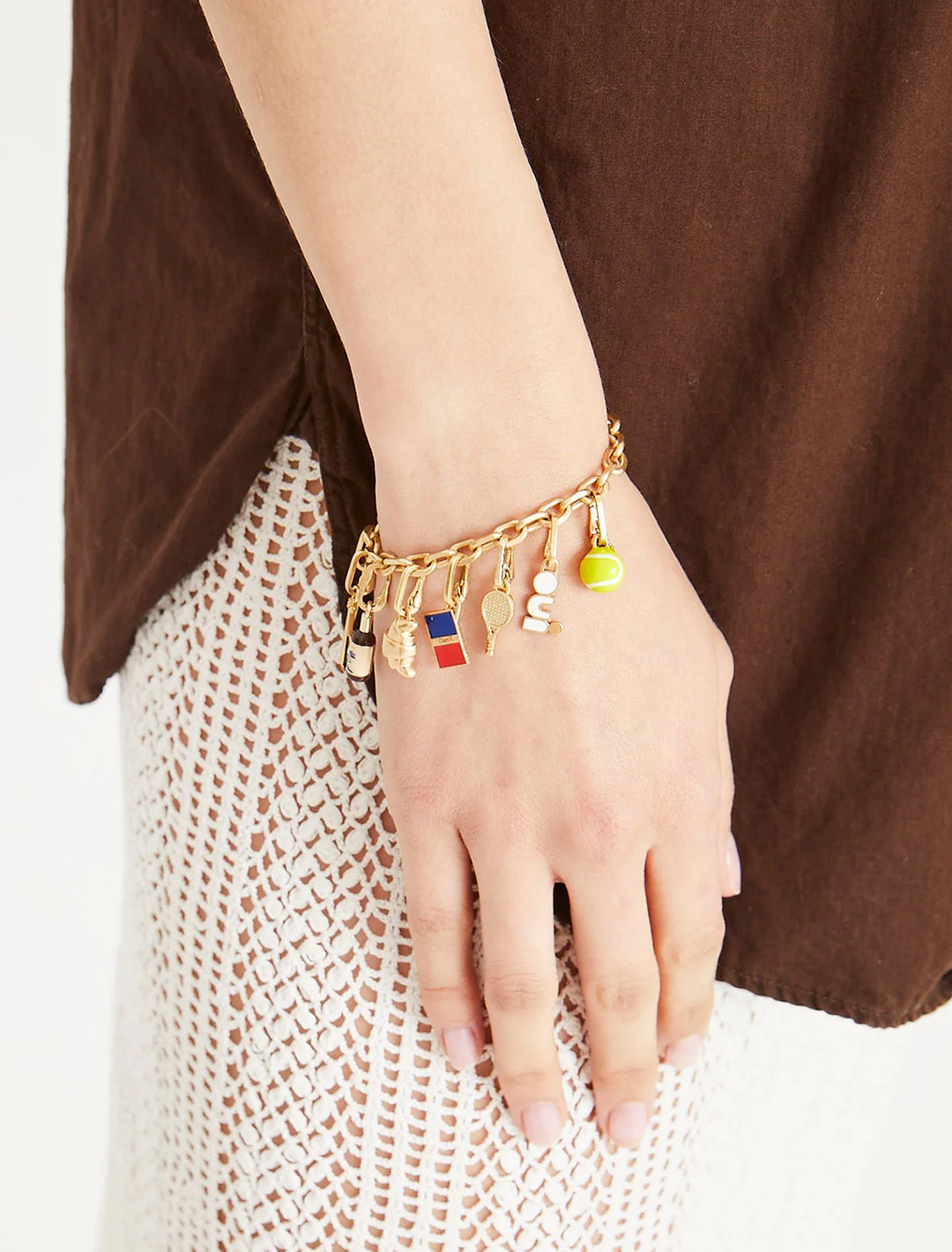Model wearing Clare V.'s tennis racquet charm on a bracelet.