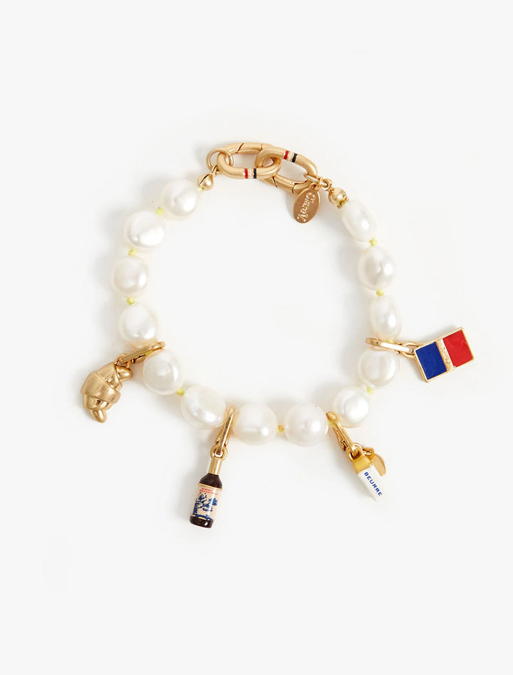 Clare V.'s vin rouge charm attached to a charm bracelet.