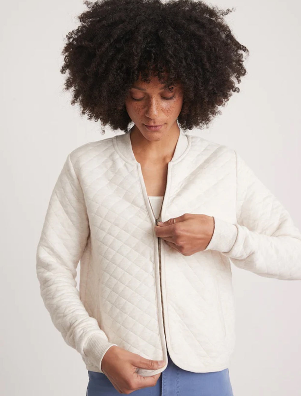 Model wearing Marine Layer's corbet quilted bomber in oatmeal.