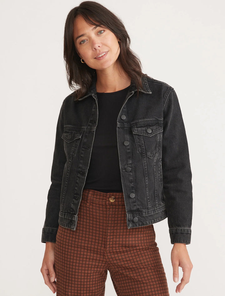 Model wearing Marine Layer's oversized denim jacket in washed black.