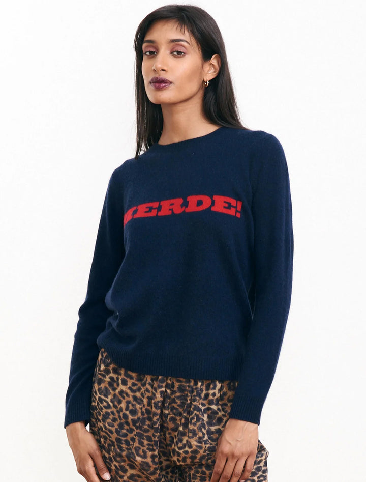 Model wearing Jumper 1234's merde sweater in navy and red.
