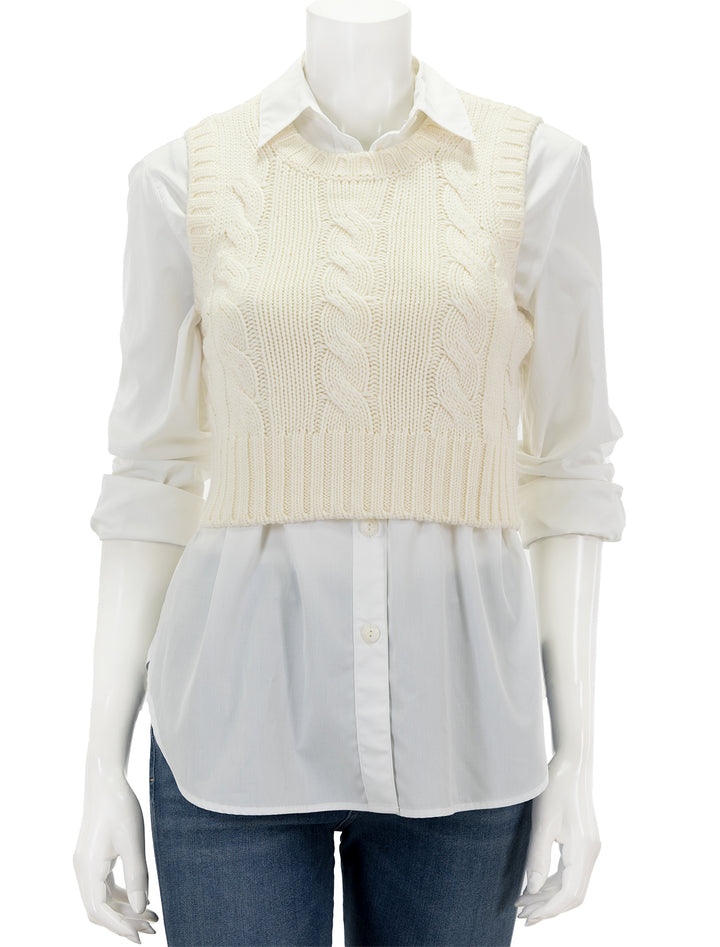 Front view of STAUD's pingo sweater vest in ivory, layered over a white button up shirt.