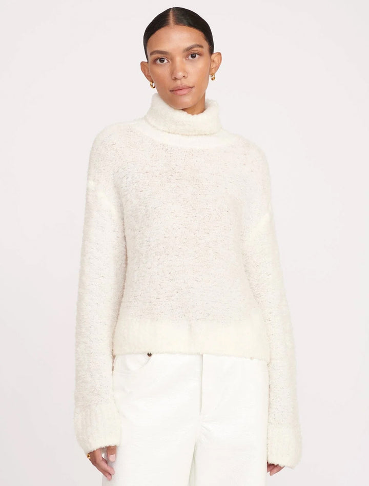 Model wearing STAUD's ezio sweater in white.