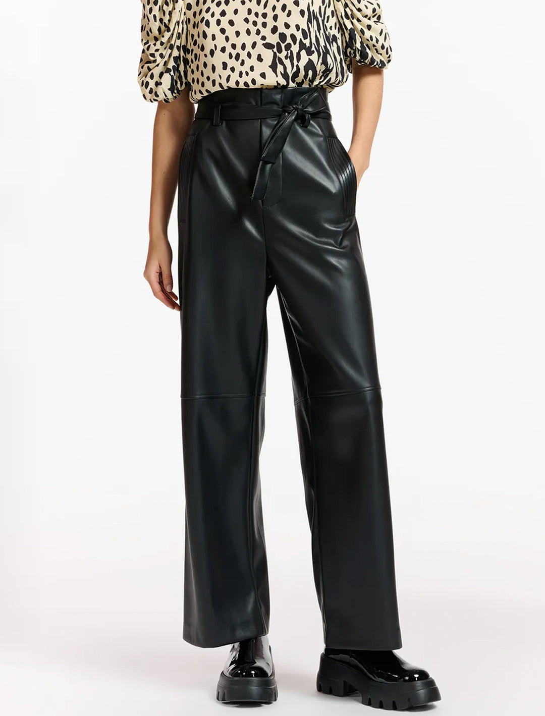 Model wearing Essentiel Antwerp's encounter faux leather pants in black.