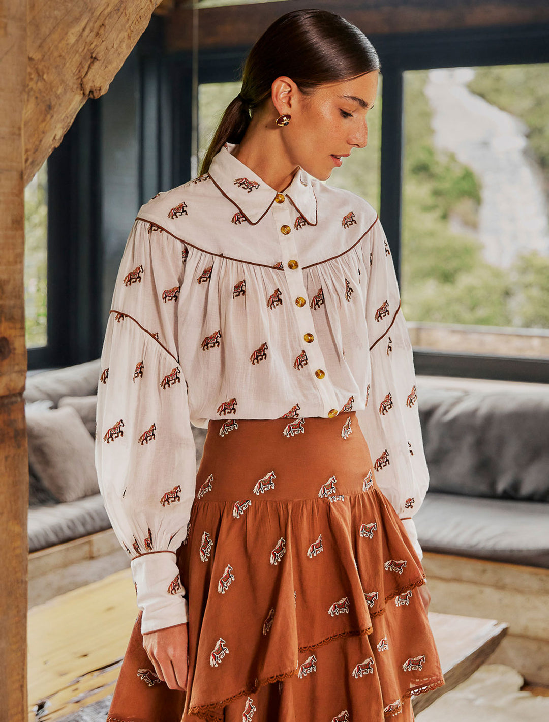 model wearing embroidered horses blouse with terracotta skirt