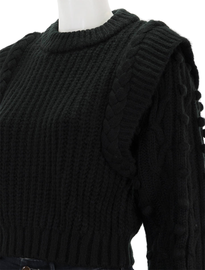Close-up view of FARM Rio's black braided sweater.