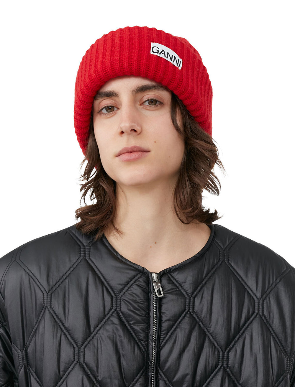 Model wearing GANNI's structured rib beanie in racing red.