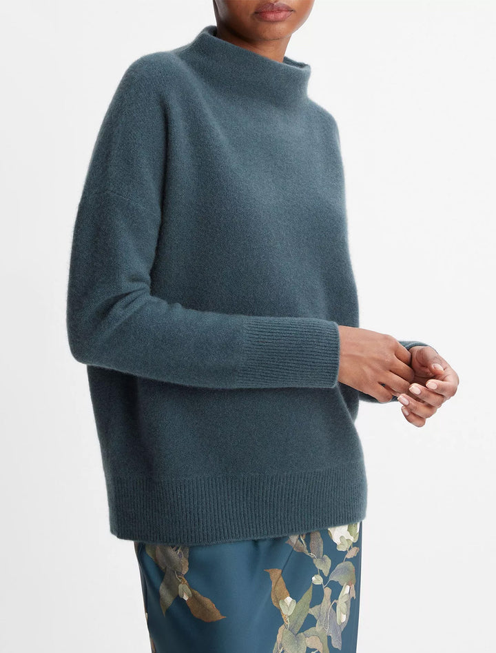 Model wearing Vince's funnel neck sweater in azurine.