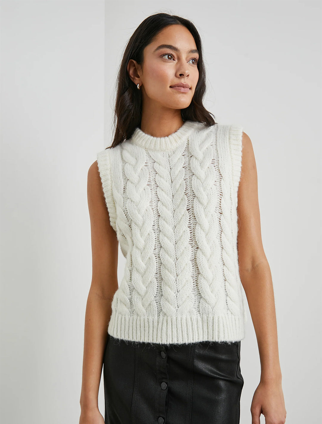 model wearing alexis sweater vest in ivory with a black leather skirt