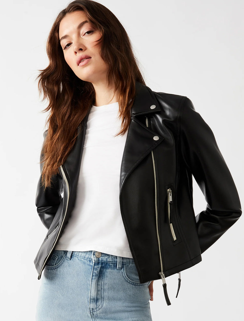 Model wearing Steve Madden's vinka jacket in black with a white tee and blue jeans.