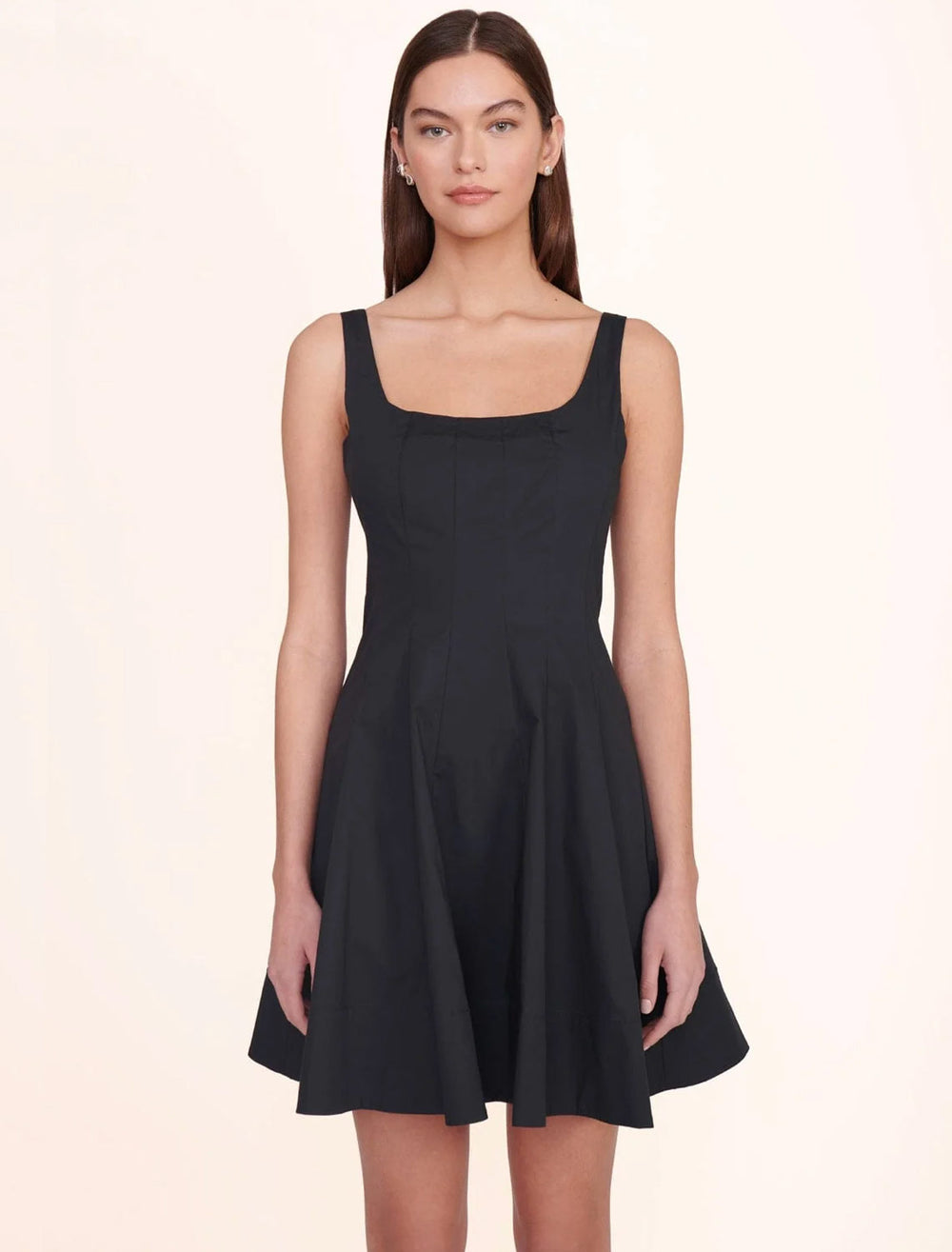 Model wearing STAUD's mini wells dress in black.