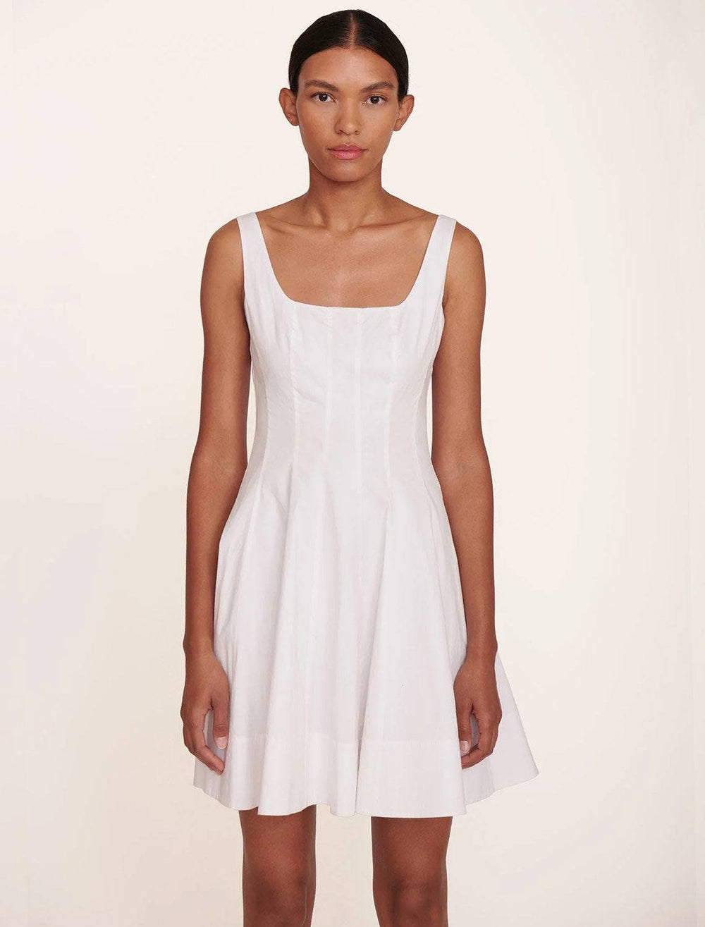 Model wearing STAUD's mini wells dress in white.