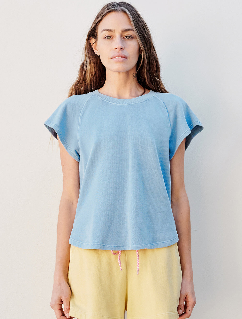 Model wearing Sundry's shirttail sweatshirt in pigment capri.
