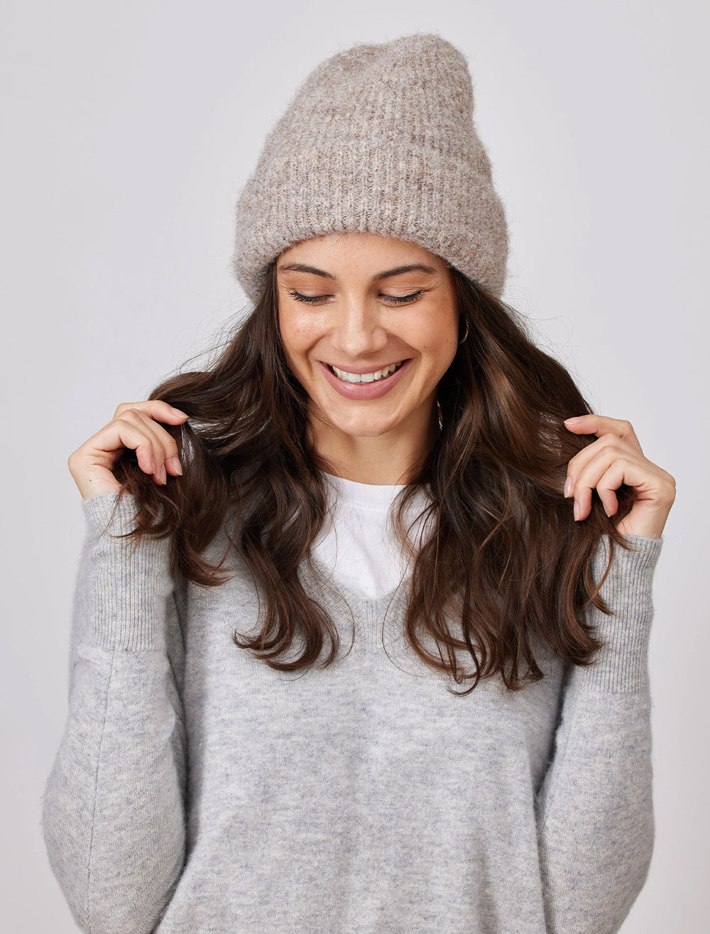 Model wearing Hat Attack's eco cuff beanie in taupe.
