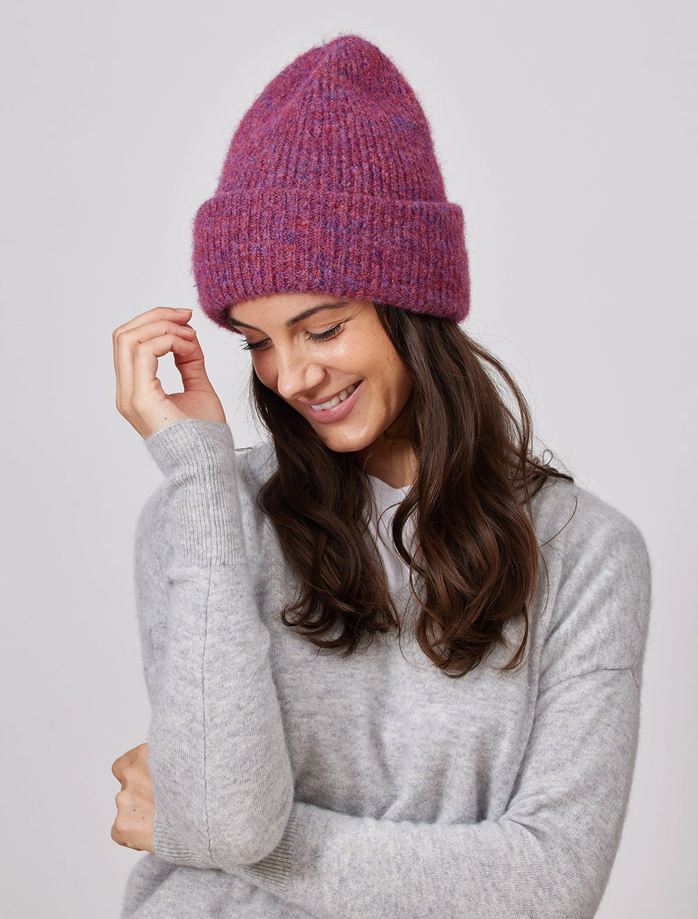Model wearing Hat Attack's eco cuff beanie in raspberry.