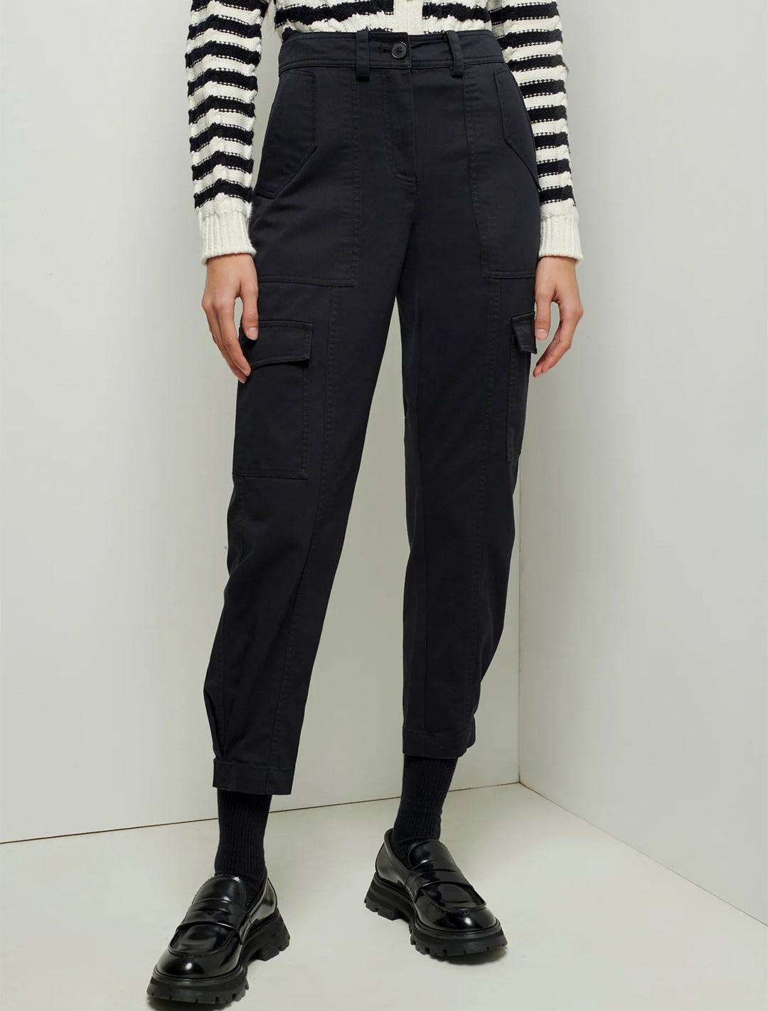model wearing elian pant in black with a striped top and loafers 