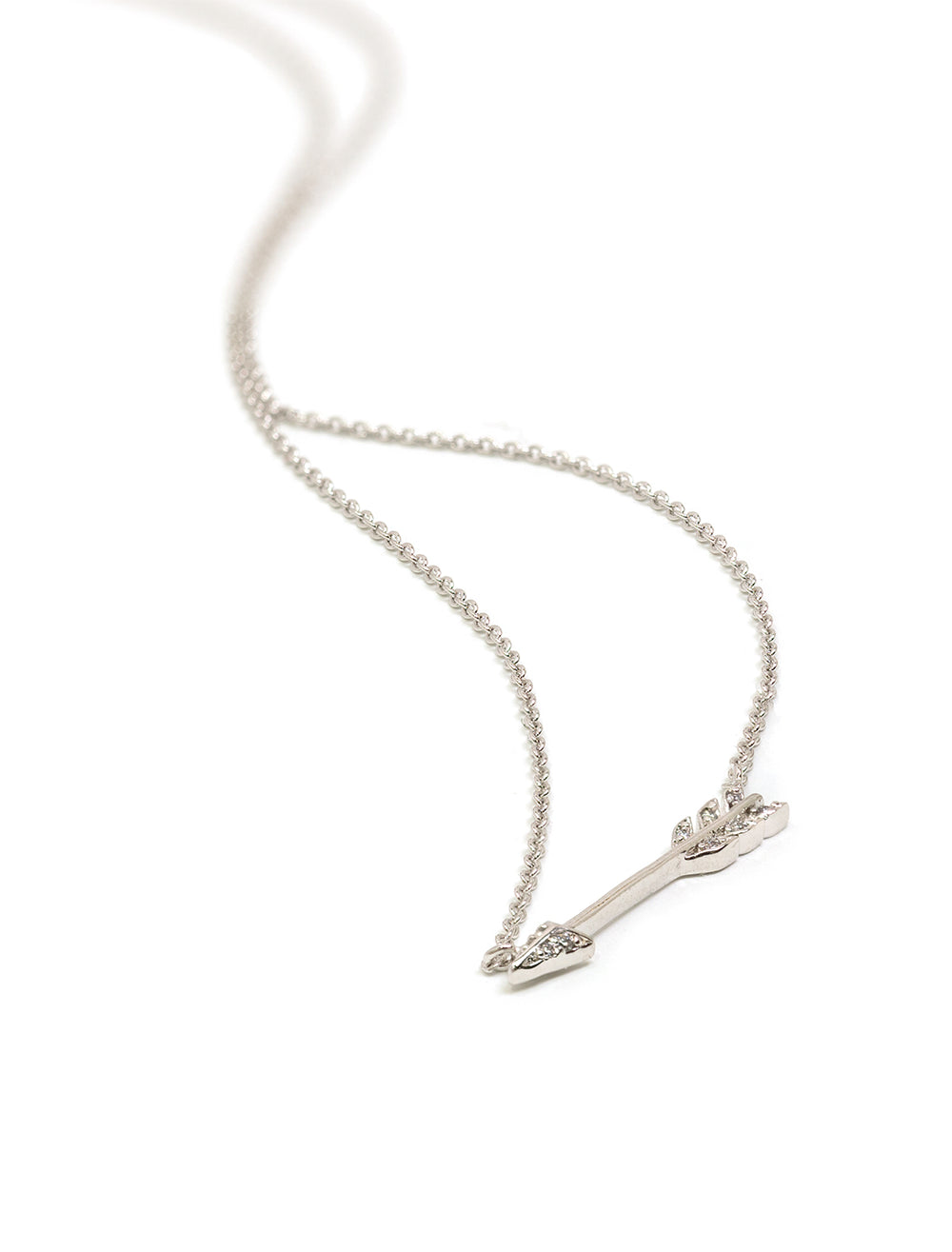 Stylized laydown of Tai Jewelry's medium arrow necklace in silver.