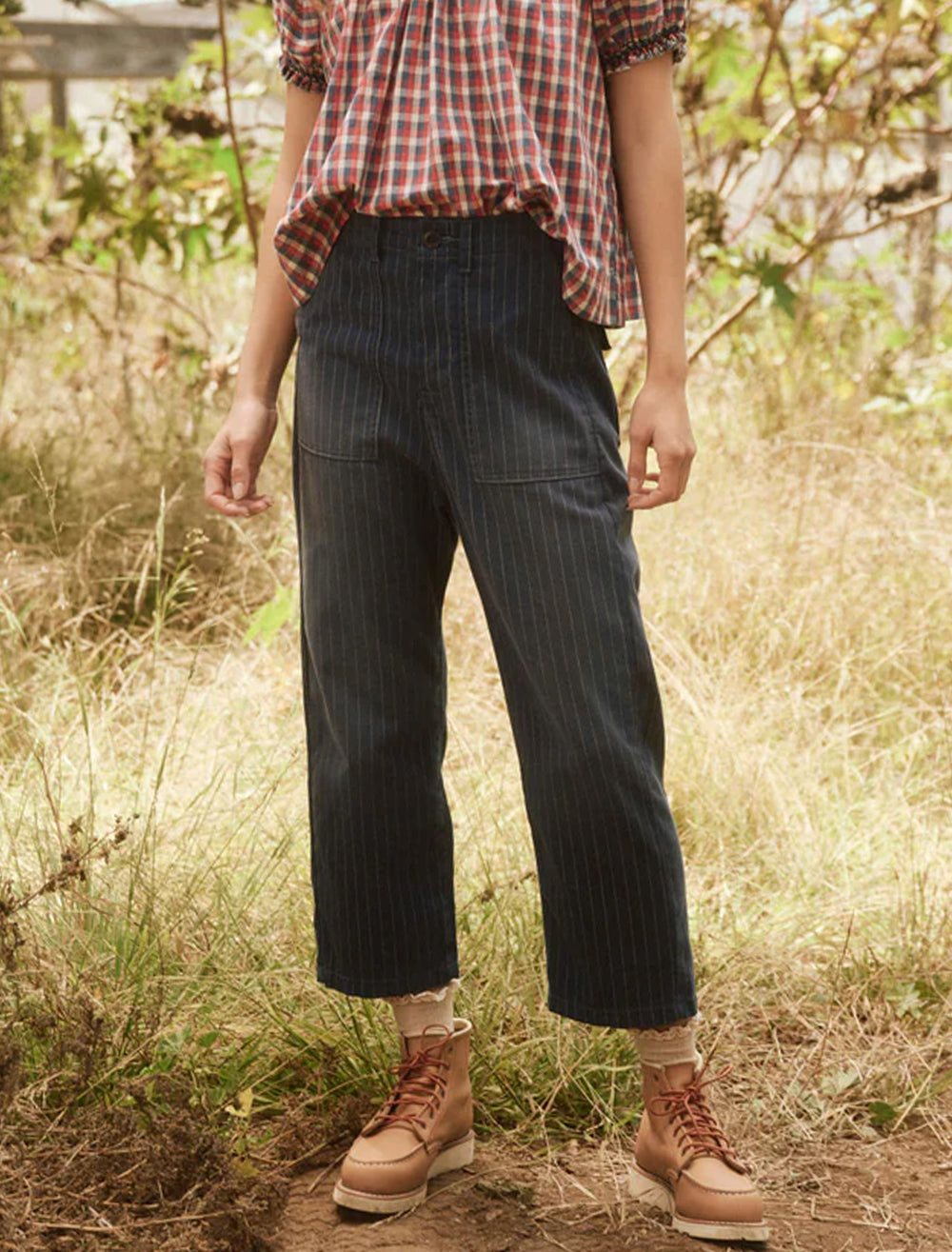 Model wearing The Great's the ranger pant in dark indigo pin stripe.