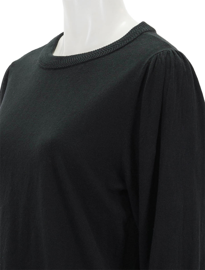 Close-up view of Lilla P.'s rib trim puff sleeve sweater in black.