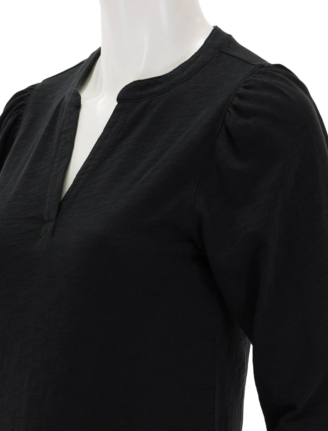 Close-up view of Lilla P.'s shirred long sleeve split neck in black.