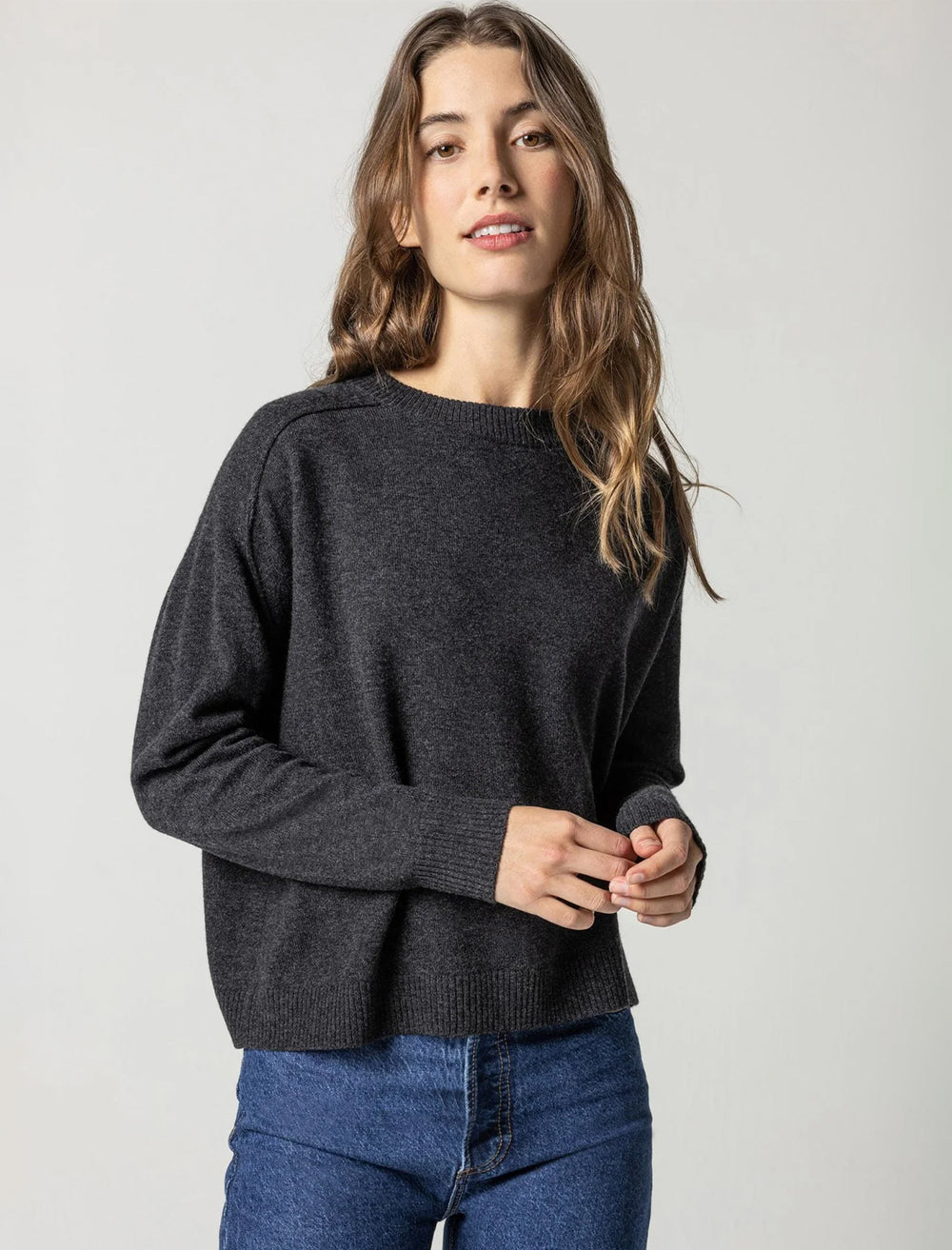 Model wearing Lilla P.'s oversized saddle sleeve sweater in graphite.
