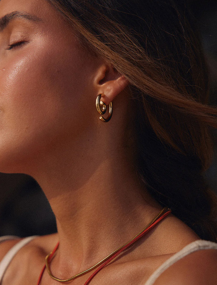 Model wearing Luv AJ's the shell beach earrings.