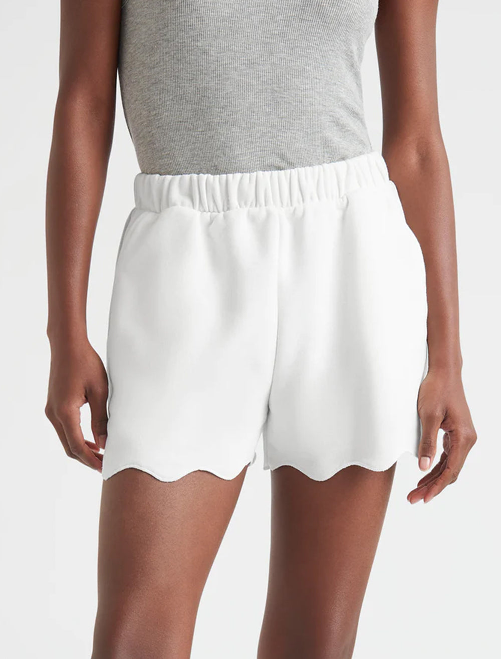 Model wearing Splendid's nori scallop trim shorts in white.