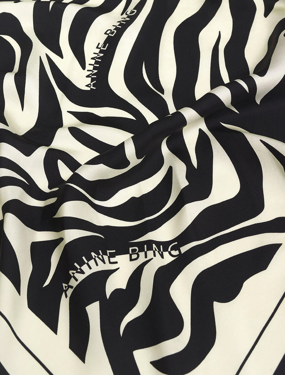 Close-up view of Anine Bing's evelyn scarf | black and cream zebra.