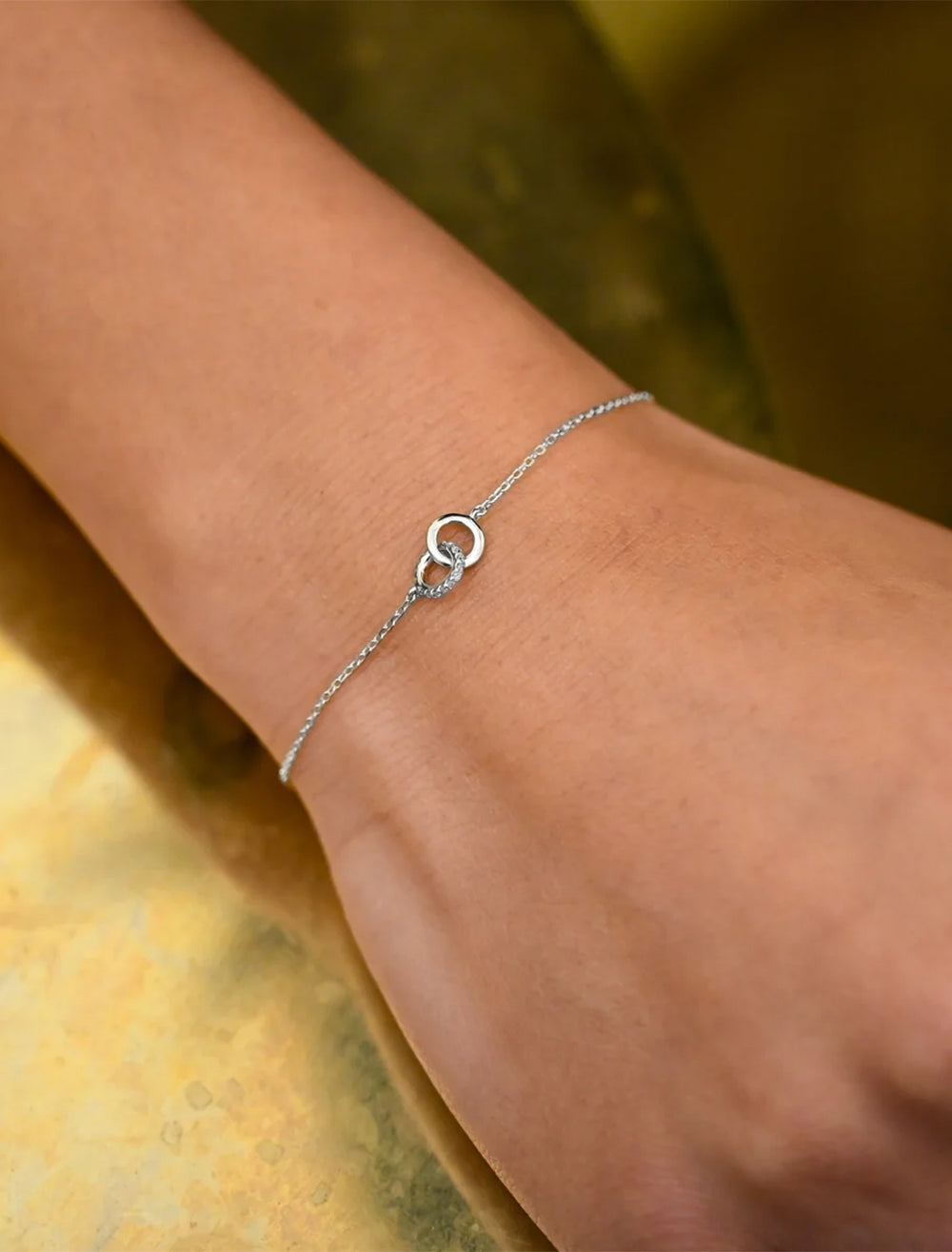 Model wearing Adina Reyter's pave interlocking loop bracelet in silver.