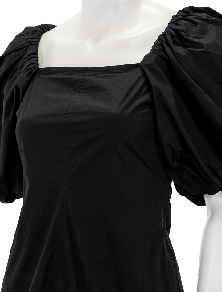 Close-up view of GANNI's cotton poplin twisted sleeve mini dress in black.