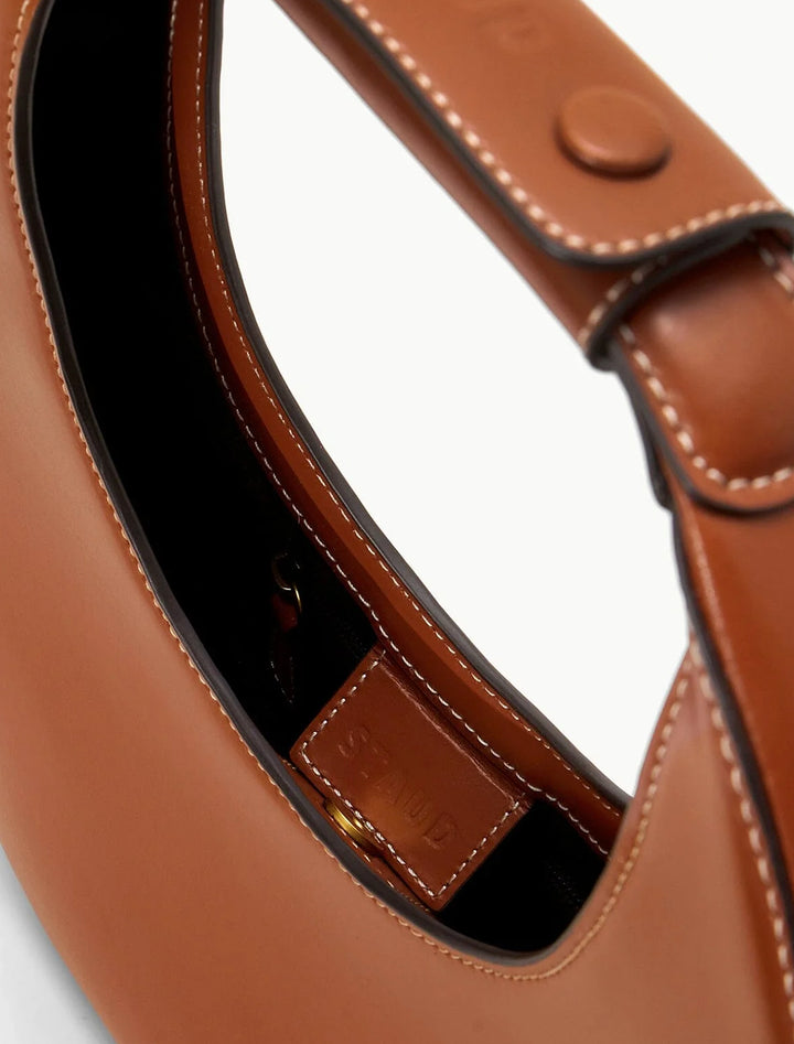 Close-up view of Staud's moon tote bag in tan.