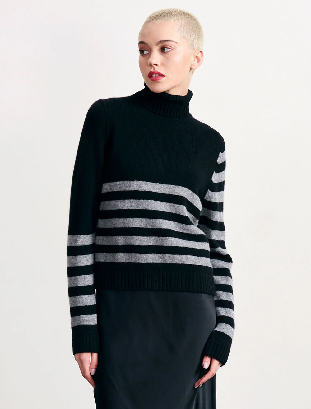Model wearing Jumper 1234's invert stripe roll collar sweater in black and cloud.
