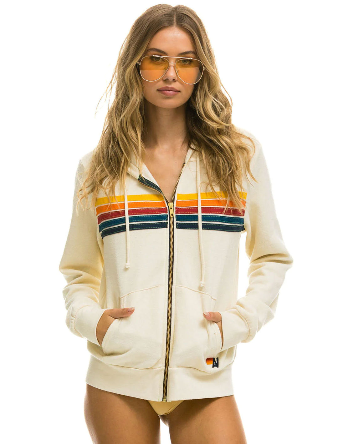 Model wearing Aviator Nation's 5 stripe zip hoodie in vintage white.