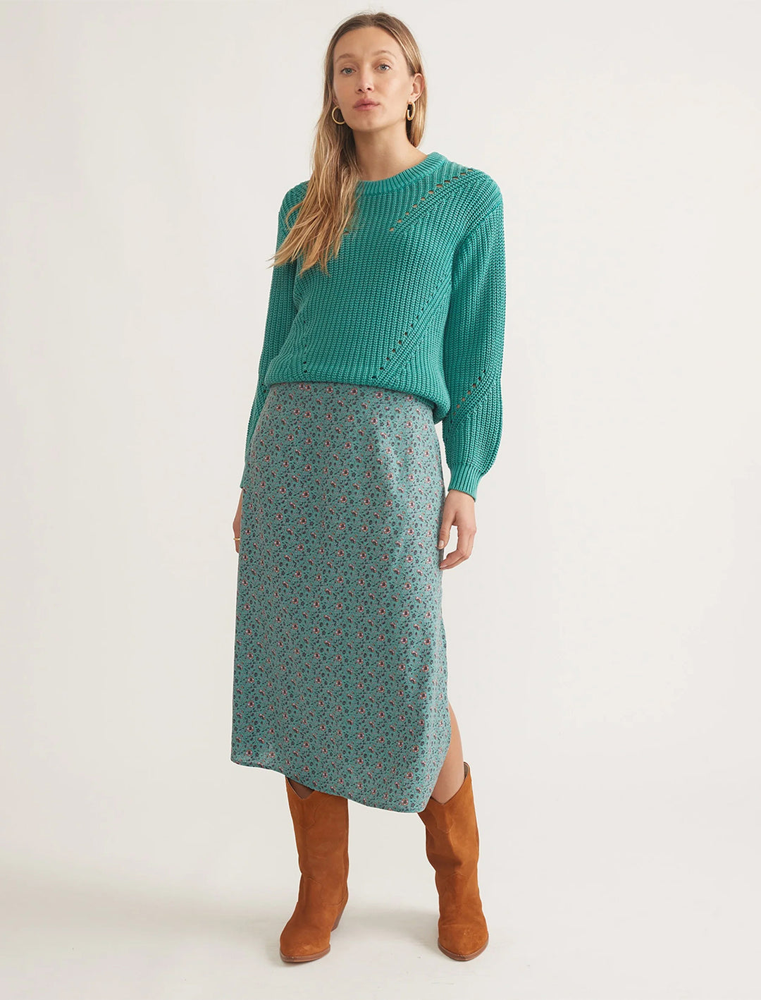 model wearing ryan midi slip skirt in deep sea floral with a green sweater and brown boots