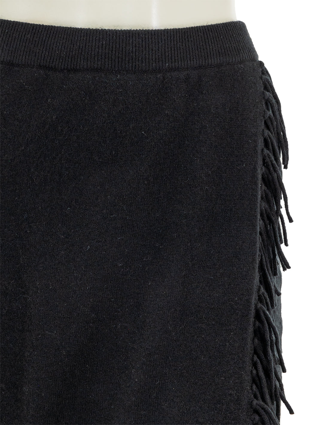 Close-up view of Minnie Rose's wrap skirt with fringe in black.
