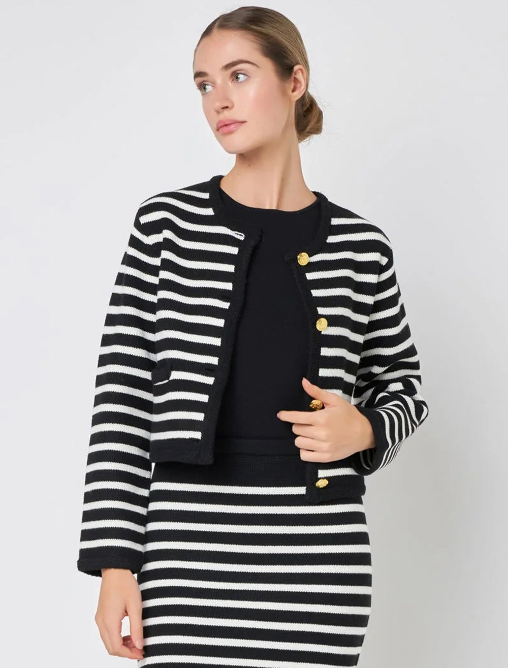 Model wearing English Factory's cardigan in black and ivory stripe.