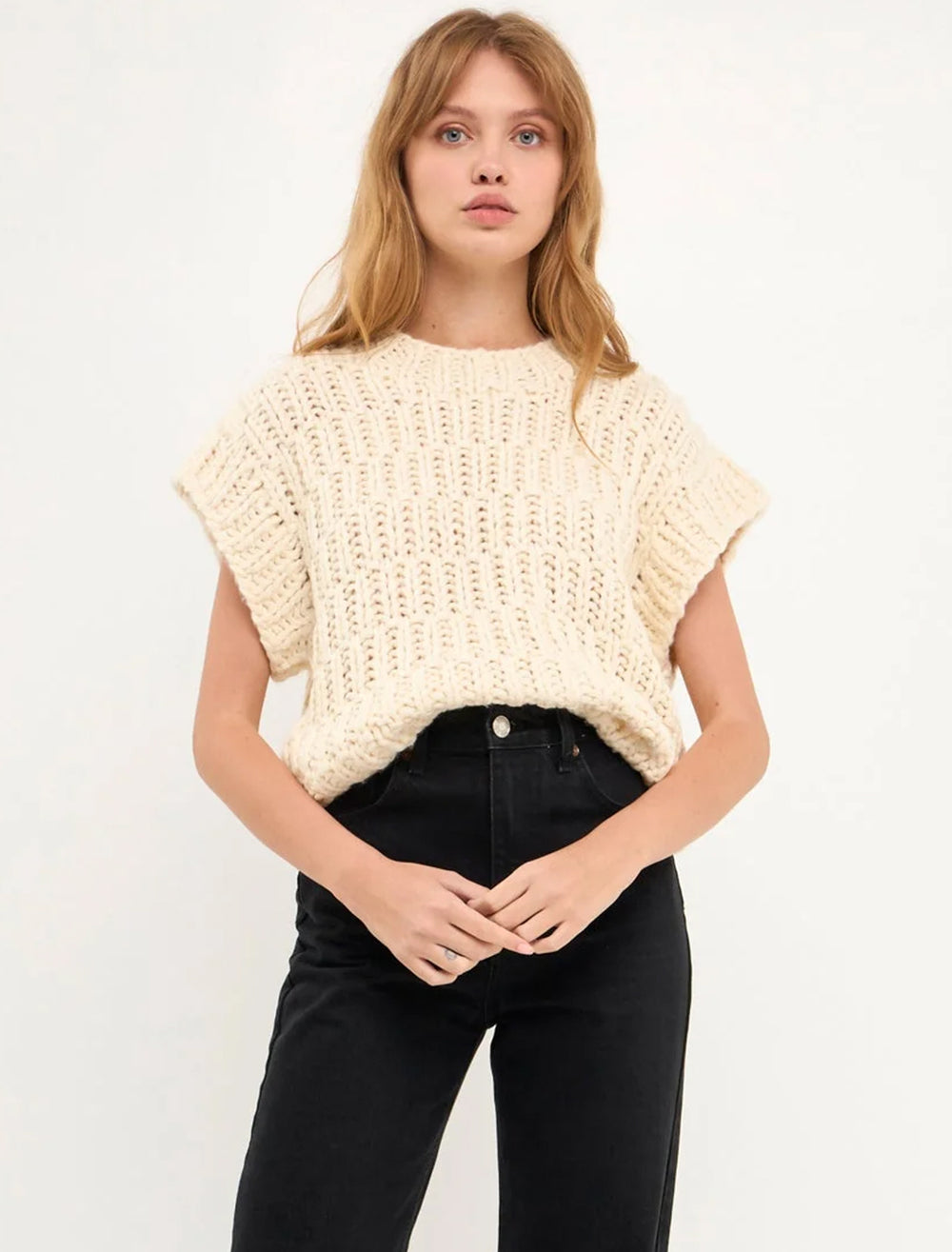 Model wearing English Factory's chunky knit sweater vest in ivory.