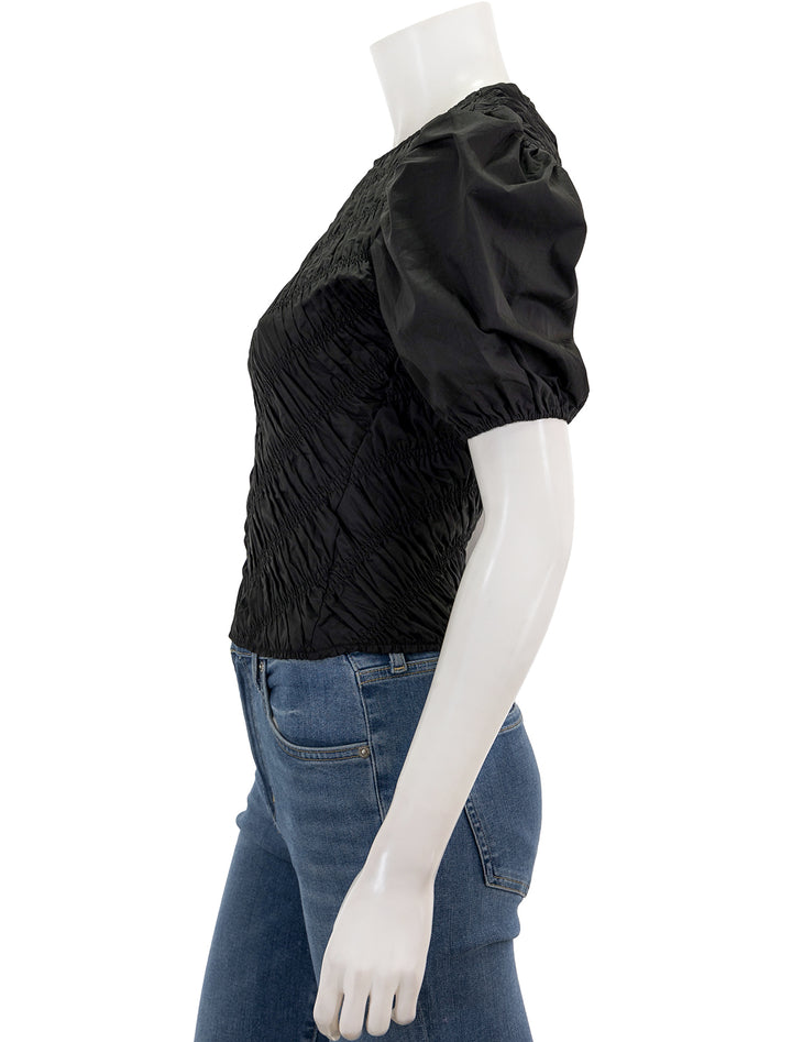 Side view of English Factory's asymmetrical smocked top in black.
