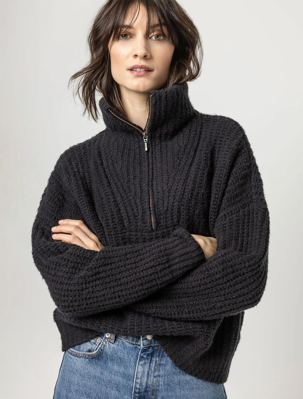 Model wearing Lilla P.'s ribbed half zip sweater in black.