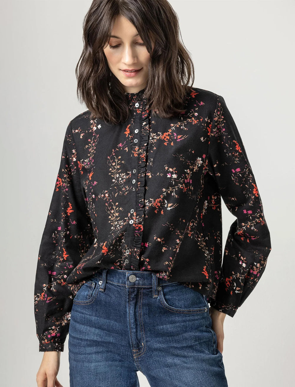 Model wearing Lilla P.'s ruffle button down blouse in black floral print.