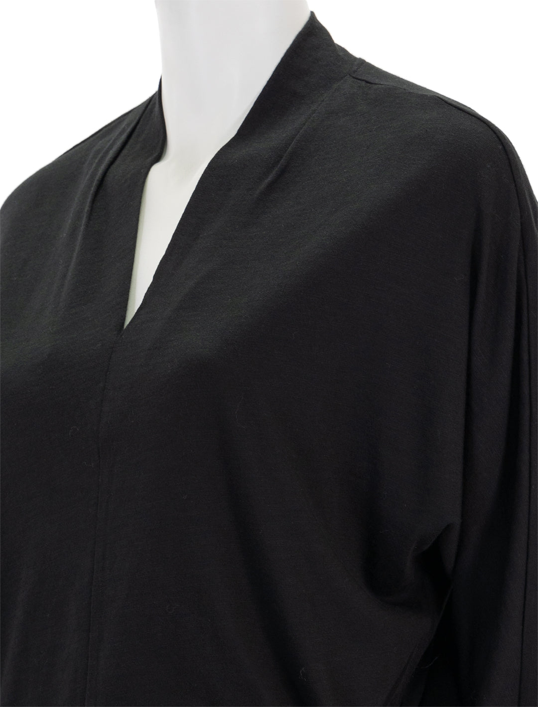 Close-up view of Lilla P.'s full sleeve split neck top in black.