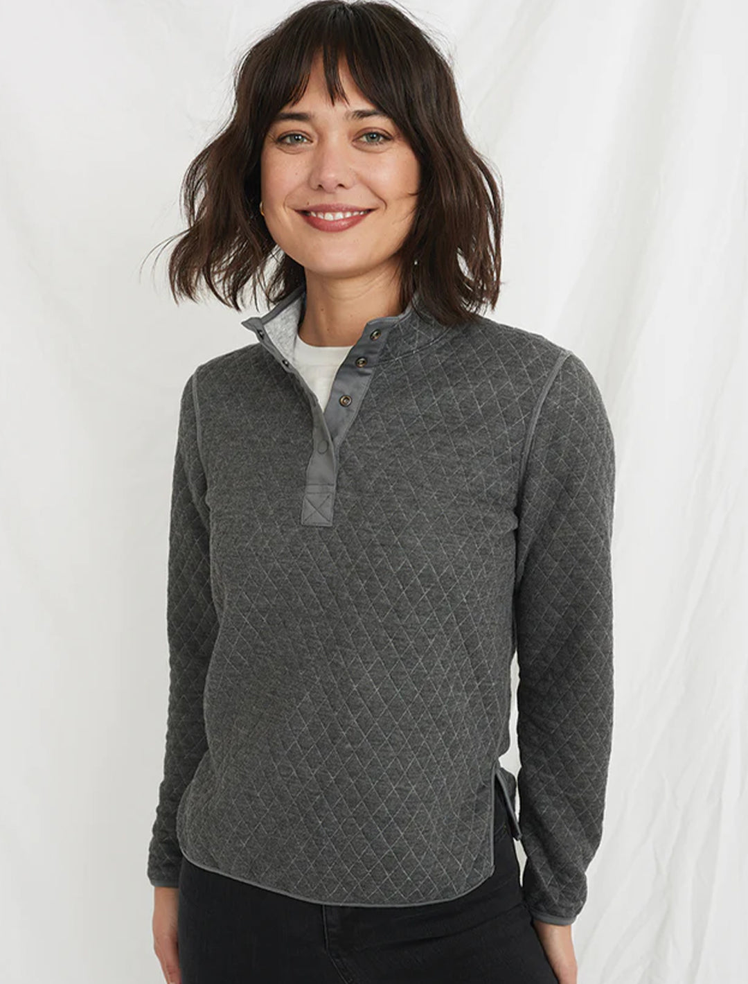 Model wearing Marine Layer's reversible corbet pullover in charcoal and heather grey on the reverse side.