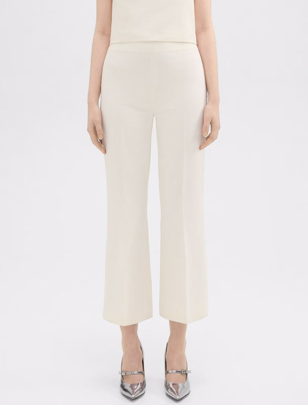 Model wearing Theory's tailored kick pant in ivory.