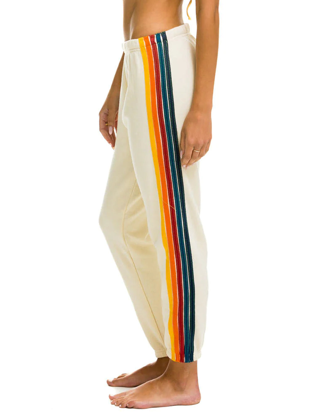 Model wearing Aviator Nation's 5 stripe womens sweatpants in vintage white.