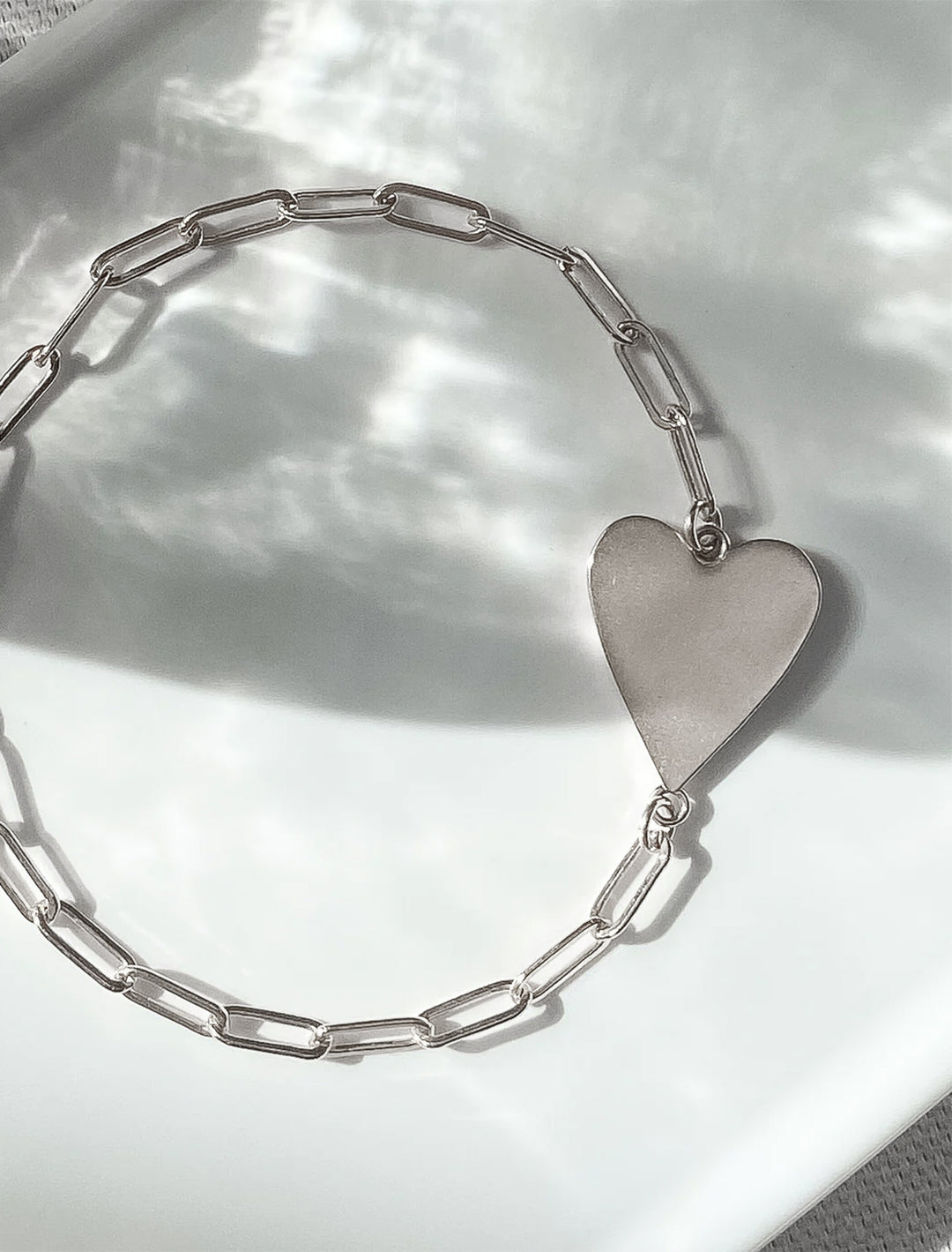 Stylized laydown of THATCH's amaya heart bracelet in silver.