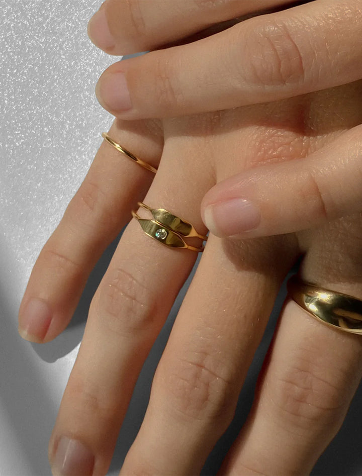 model wearing stacking signet ring with stone in gold