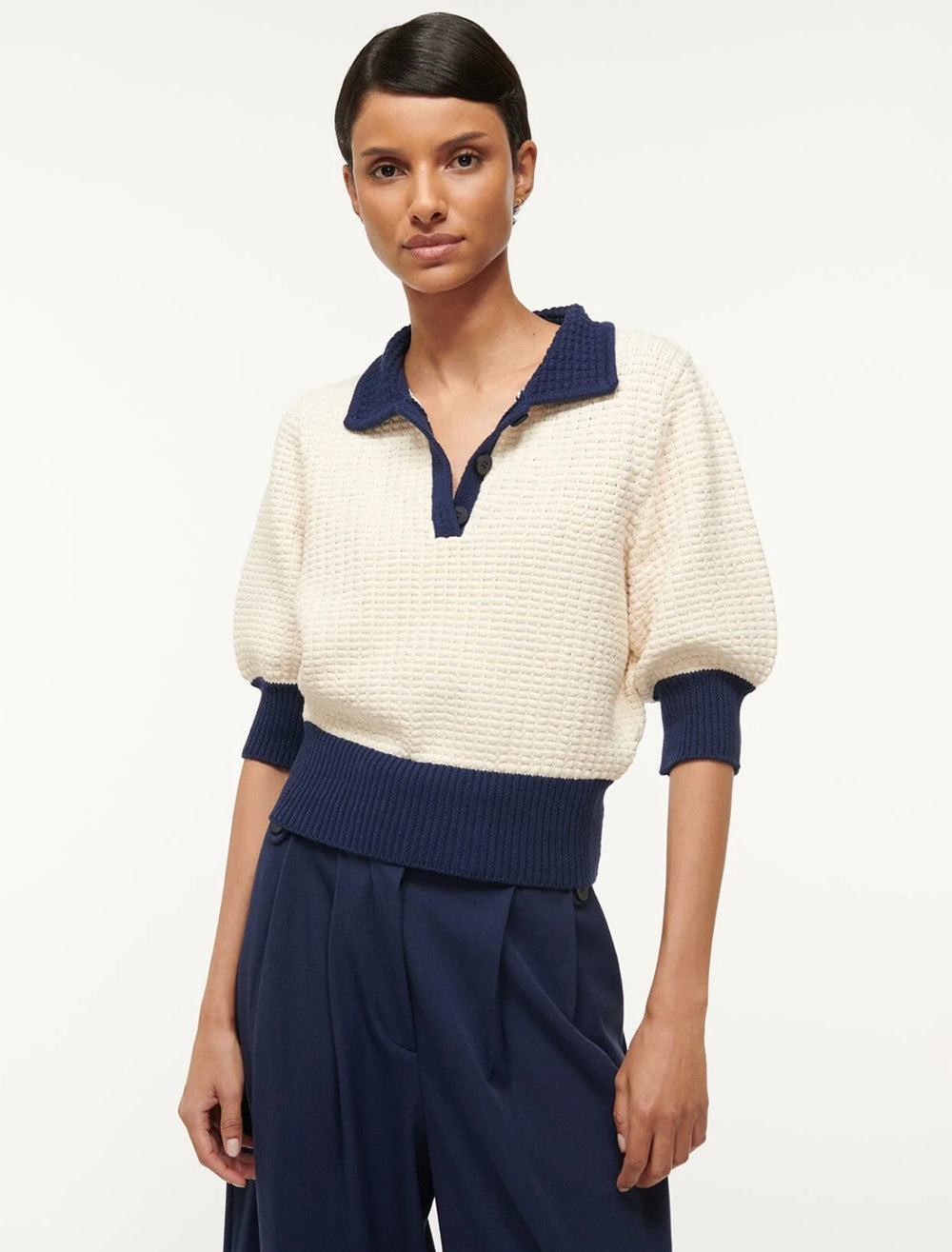 Model wearing Staud's altea sweater in ivory and navy.